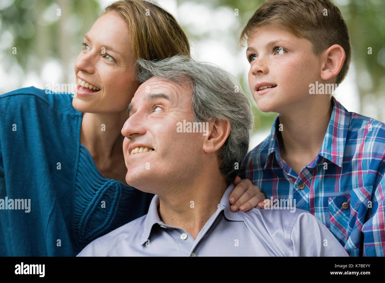 Famiglia insieme sorridente e guardando lontano, ritratto Foto Stock
