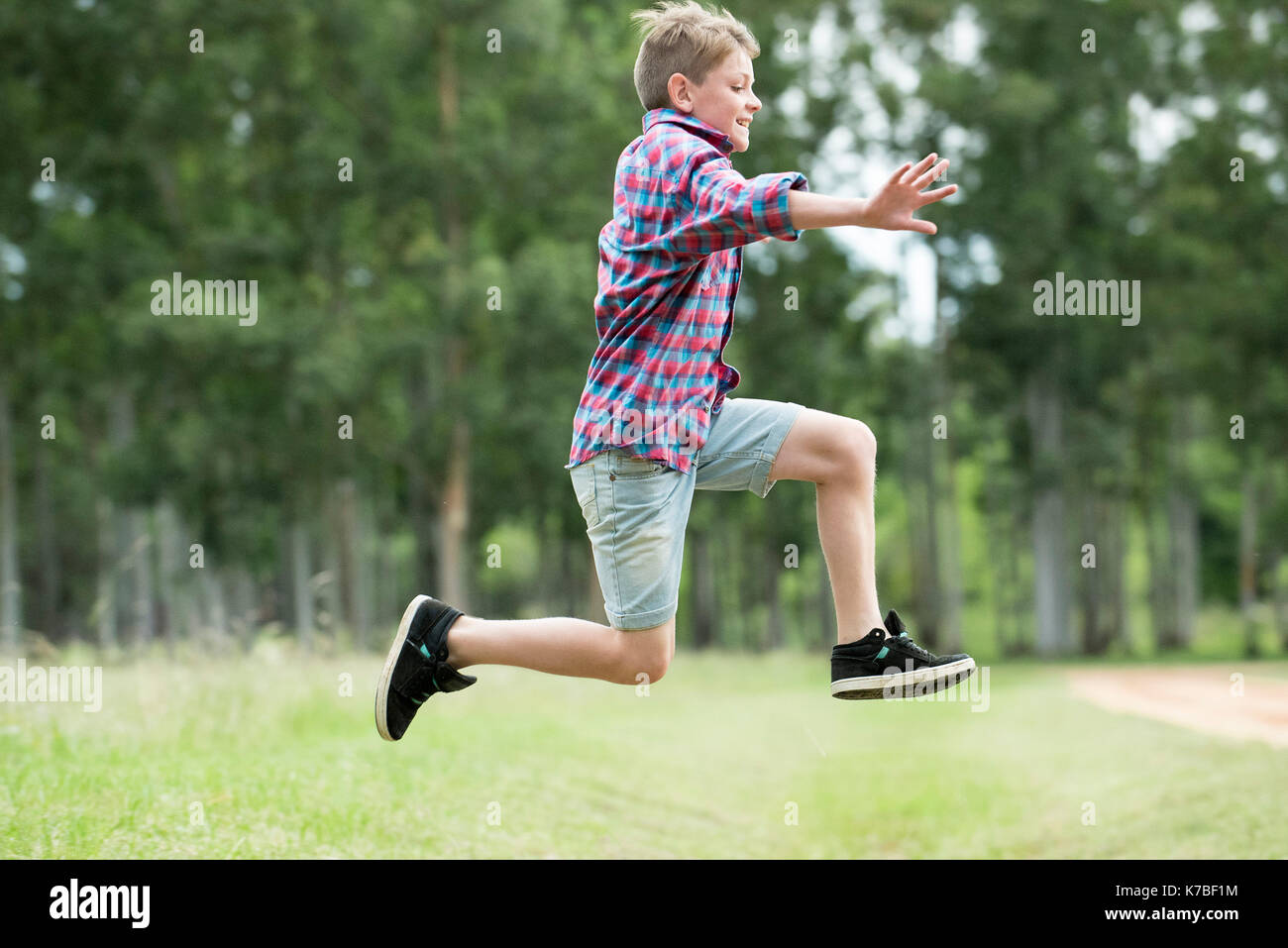 Boy jumping in midair Foto Stock