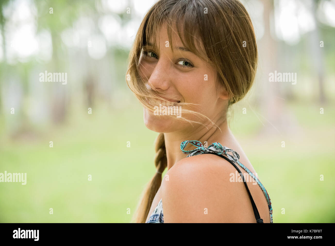 Giovane donna sorridente sulla spalla, ritratto Foto Stock