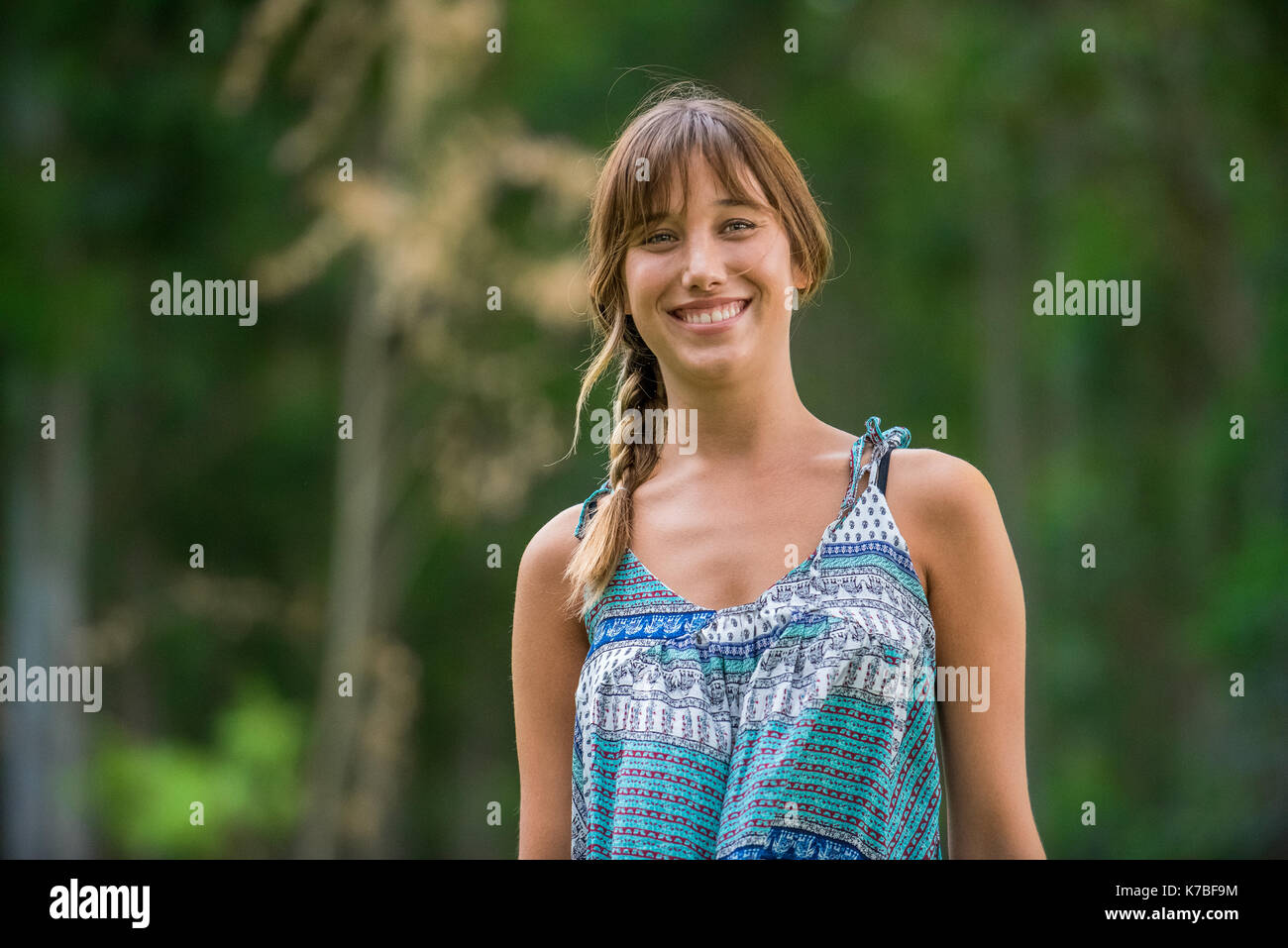 Giovane donna sorridente all'aperto, ritratto Foto Stock