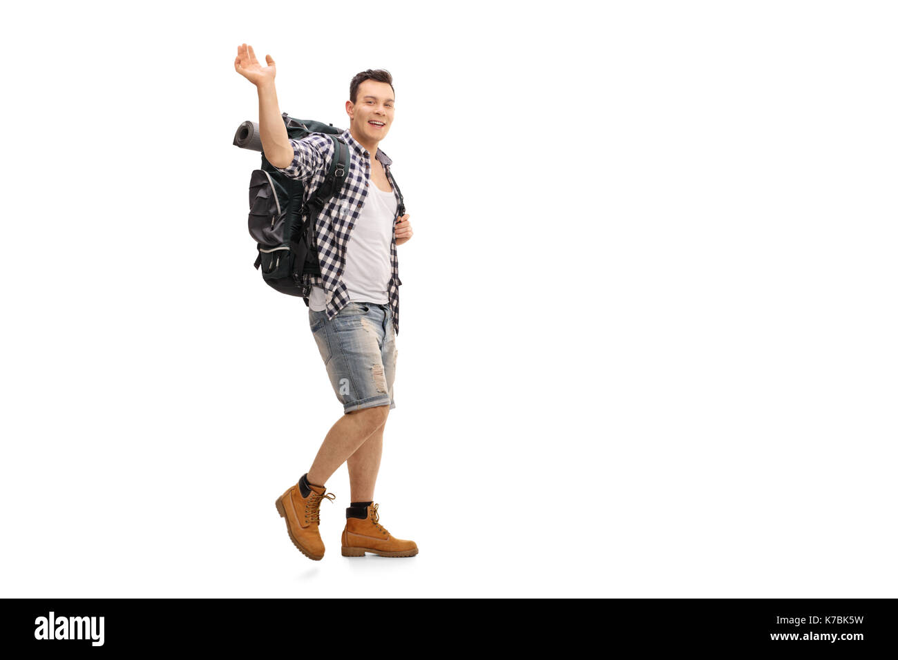 A piena lunghezza Ritratto di un escursionista a piedi e agitando la fotocamera a isolati su sfondo bianco Foto Stock