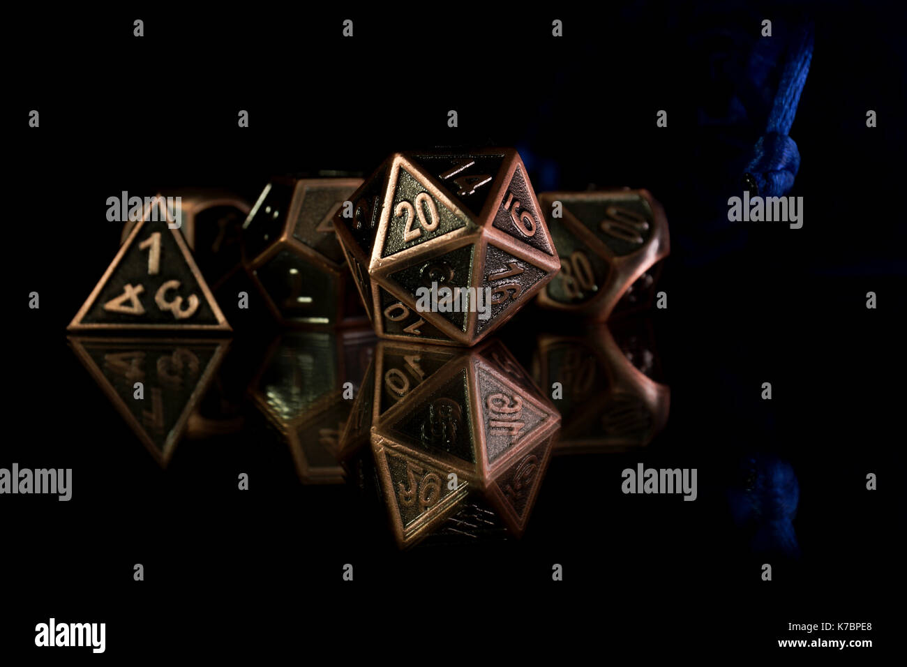 Un set di dadi poliedrica con un blu Pochette con cordone su una superficie specchiante. Questi dadi sono utilizzati per i giochi di ruolo come Dungeons & Dragons. Foto Stock