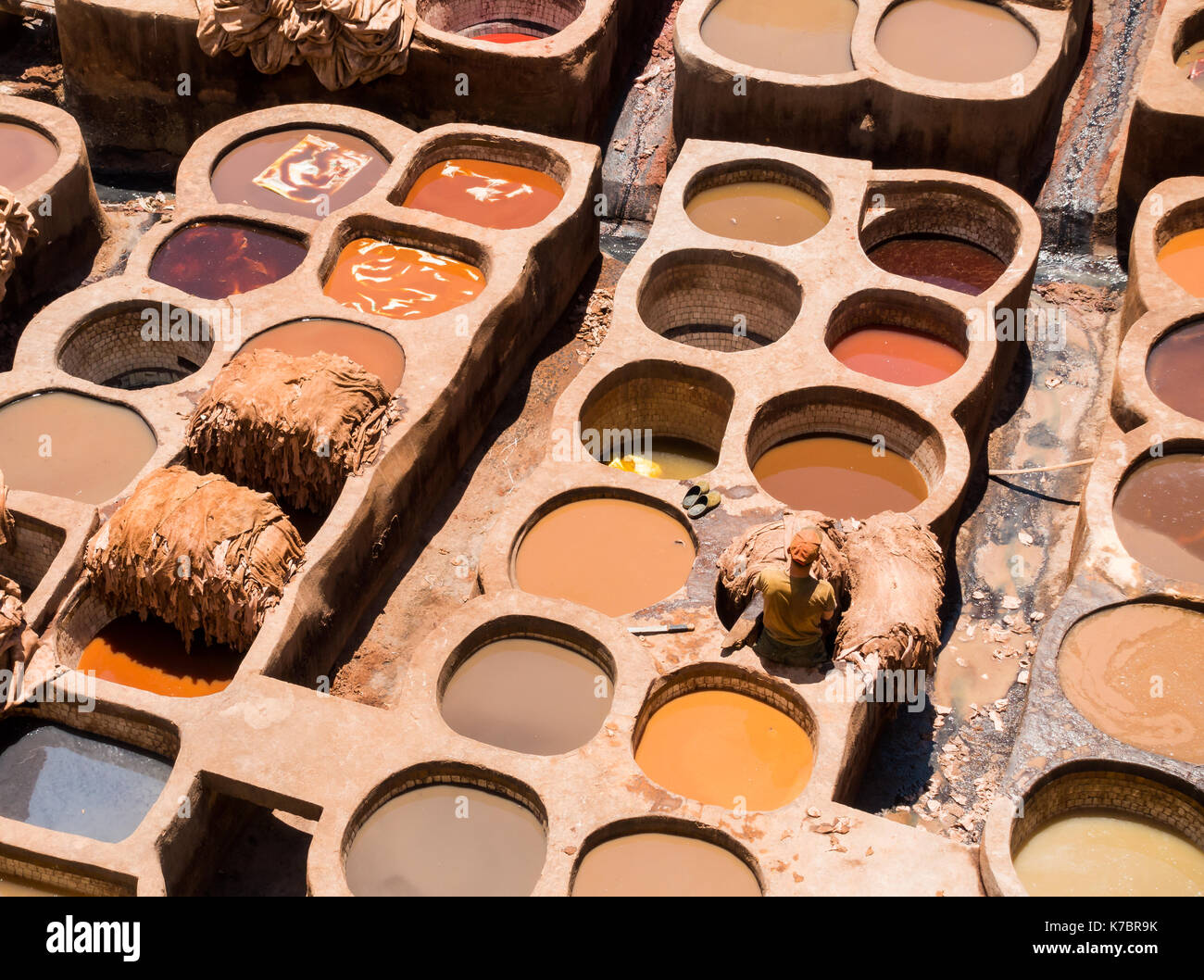 Lavoratore non identificabili in piedi in una delle vasche di tintura di cuoio in una conceria in Marocco. Foto Stock