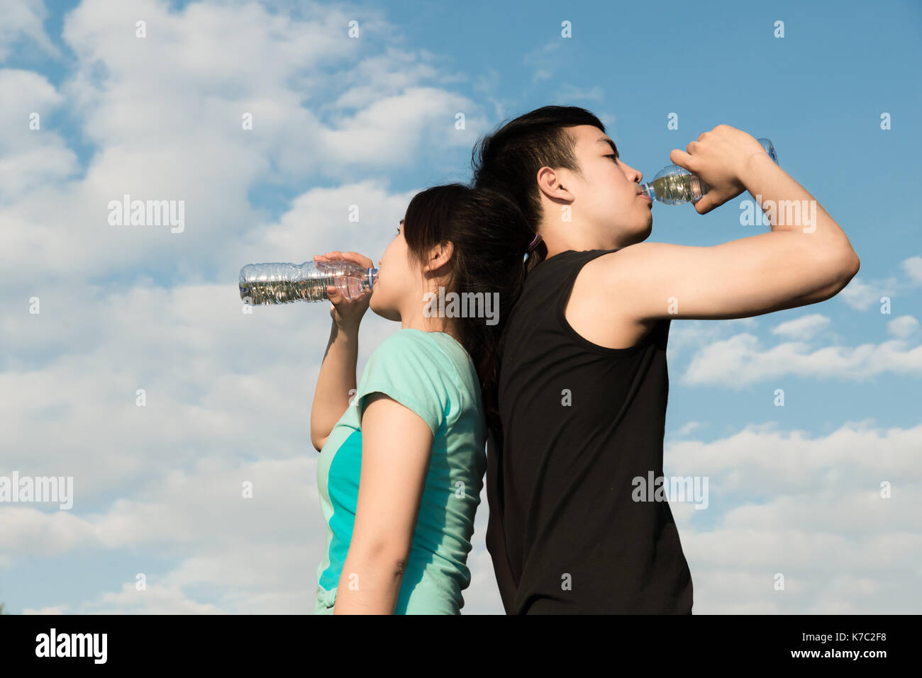 Asian giovane uomo e donna acqua potabile dalla bottiglia dopo fitness sport esercizio. Foto Stock