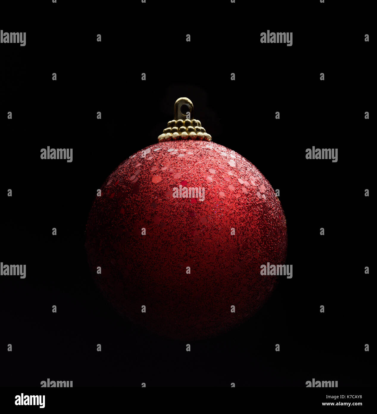 Colore rosso scintillante palla di Natale isolato su sfondo nero. Luce gradiente ambiance Foto Stock