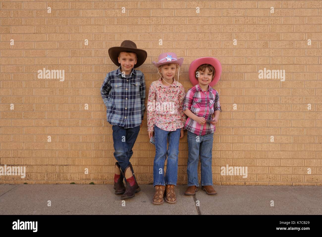 Tre bambini travestiti da cowboy Foto Stock