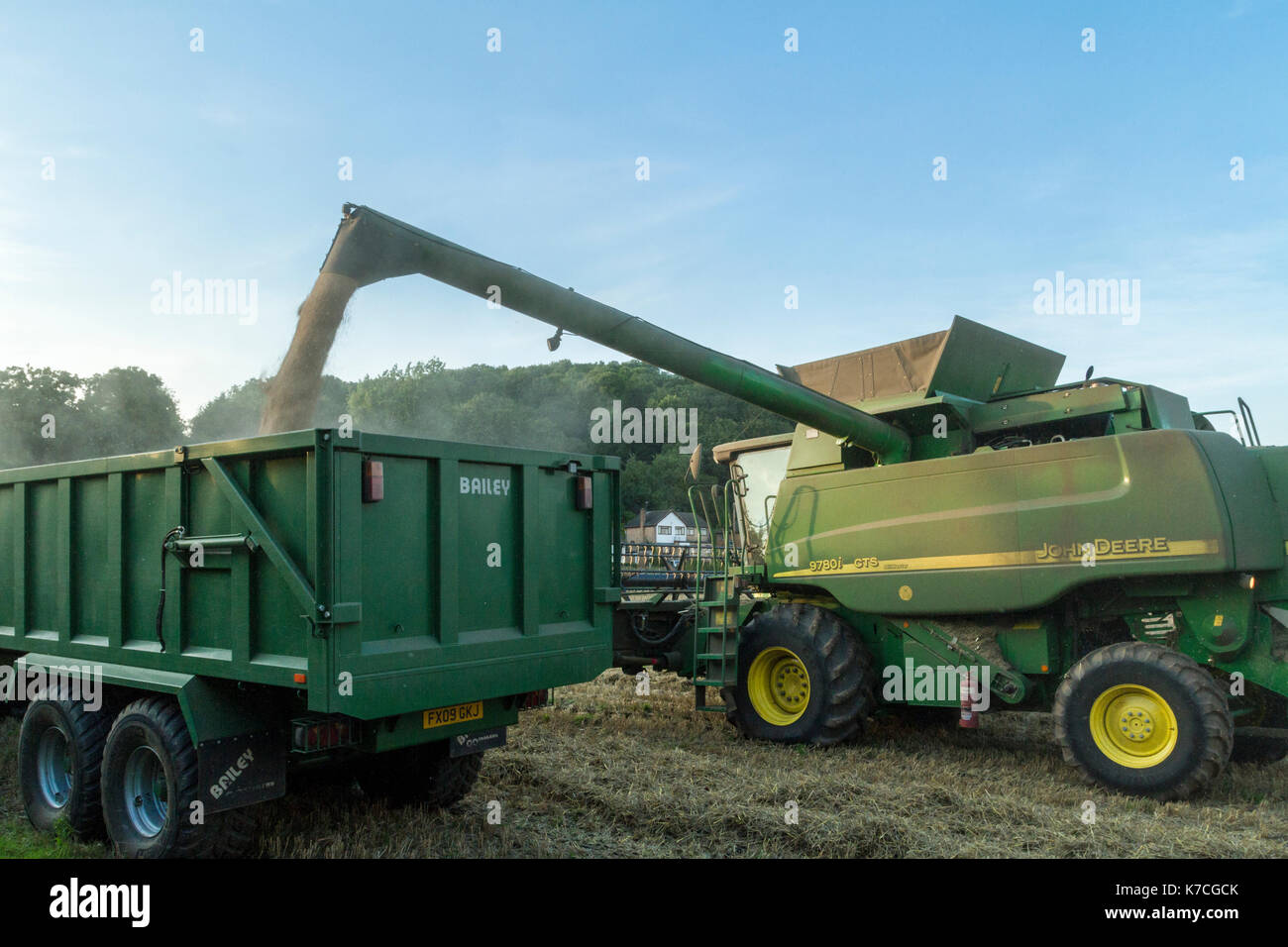 Macchina mietitrebbiatrice trasferimento grano a un rimorchio durante la mietitura del grano, Nottinghamshire, England, Regno Unito Foto Stock