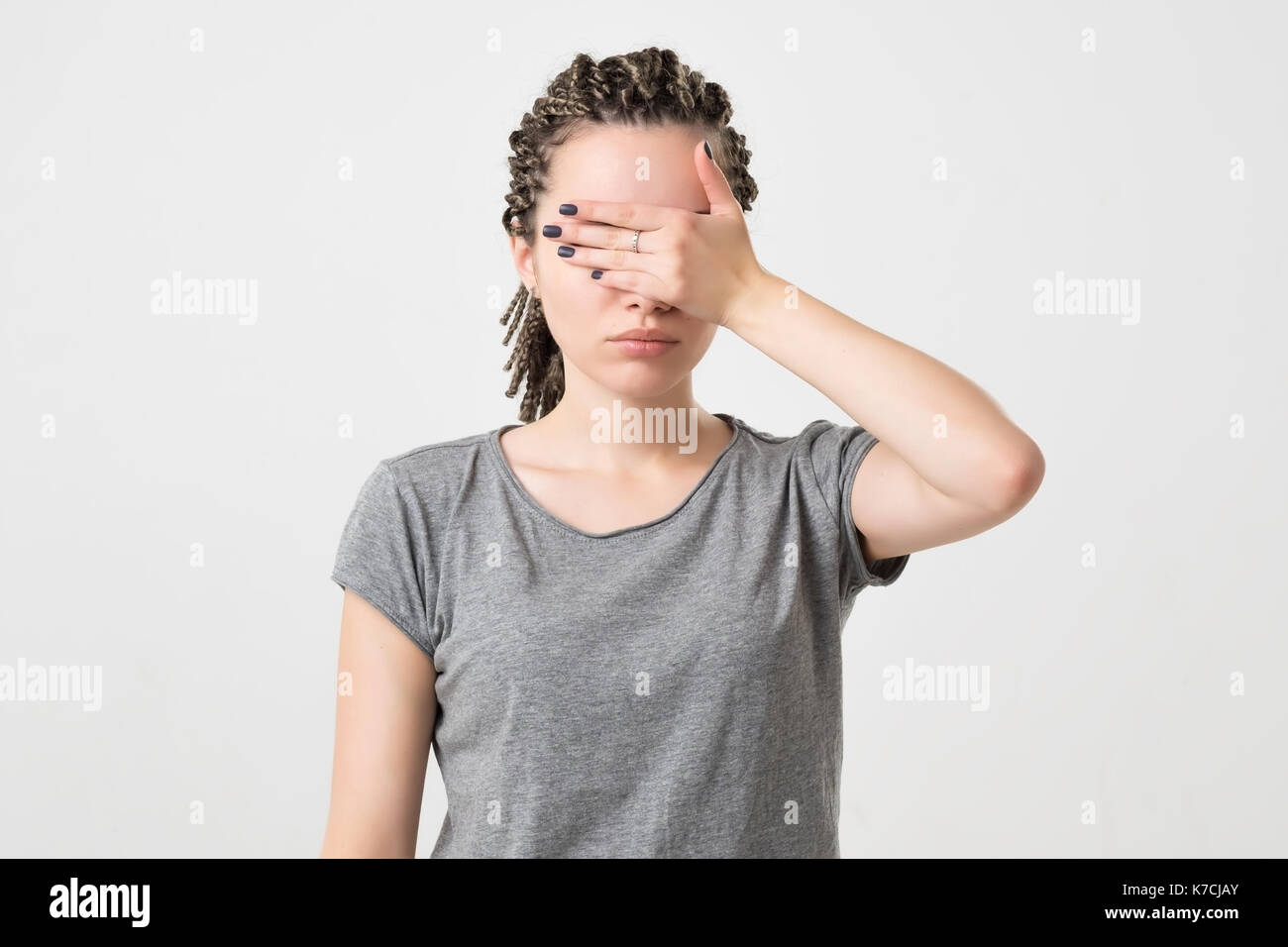 La donna caucasica che copre il volto con le mani. Foto Stock