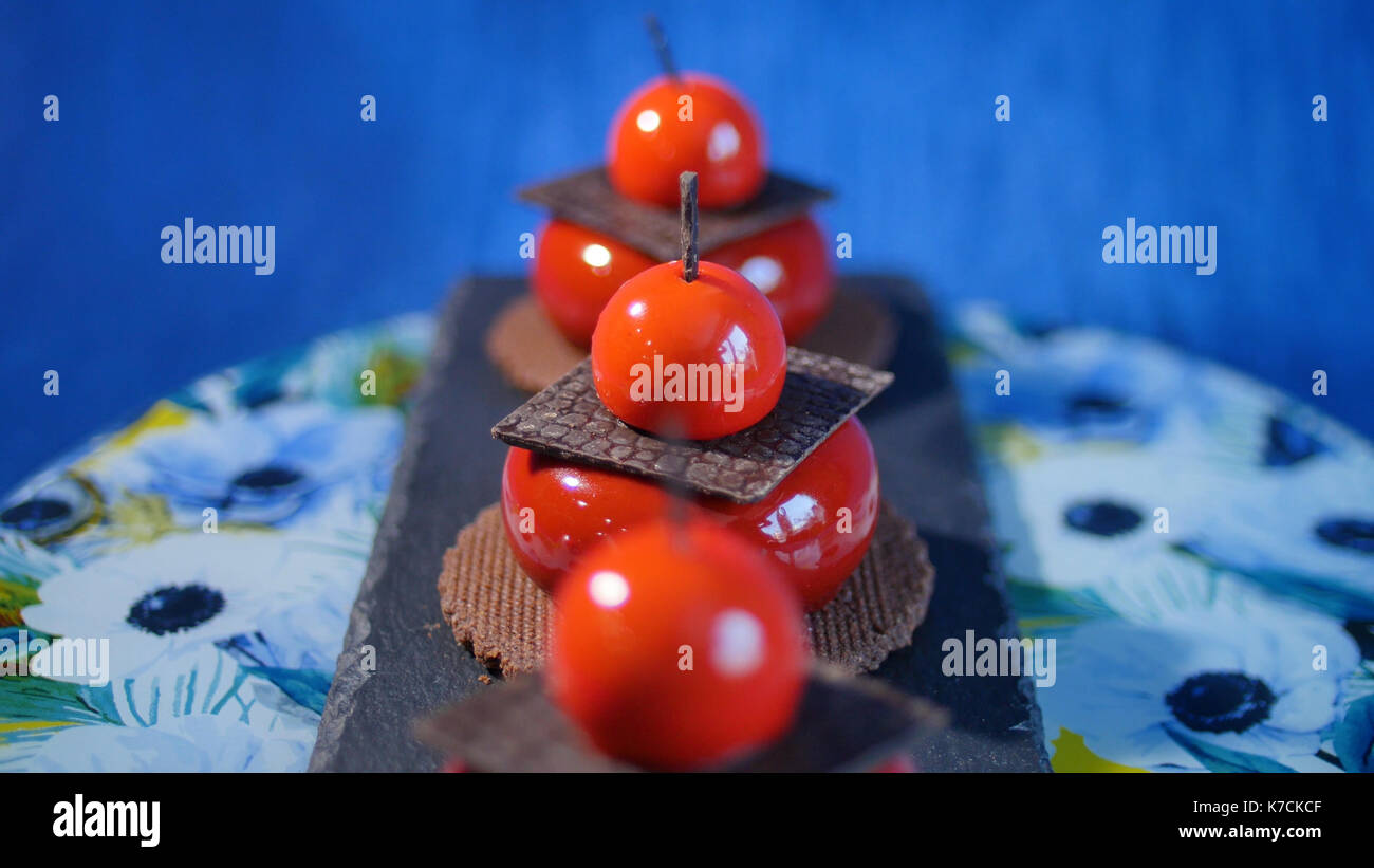 Tre rossi torta con biscotti e cioccolata. gustose torte di rosso su sfondo blu scuro Foto Stock