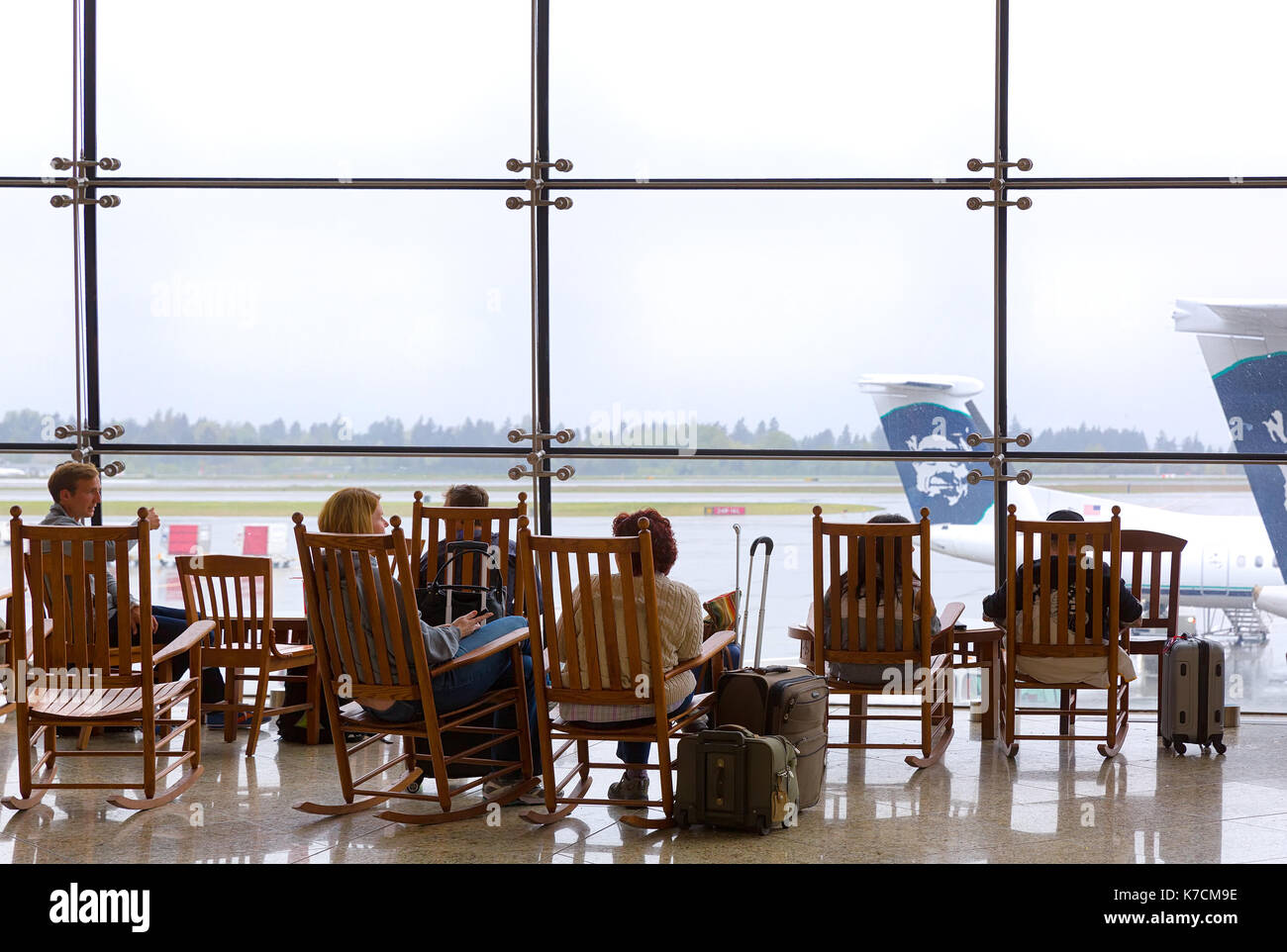 Seattle-apr 4, 2014: travelers rest in legno Sedie a dondolo al terminal principale a seatac, il Seattle-tacoma international airport. La vecchia moda Foto Stock