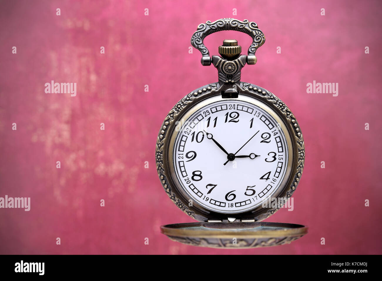 Il vecchio orologio da tasca su grunge parete rossa sullo sfondo Foto Stock