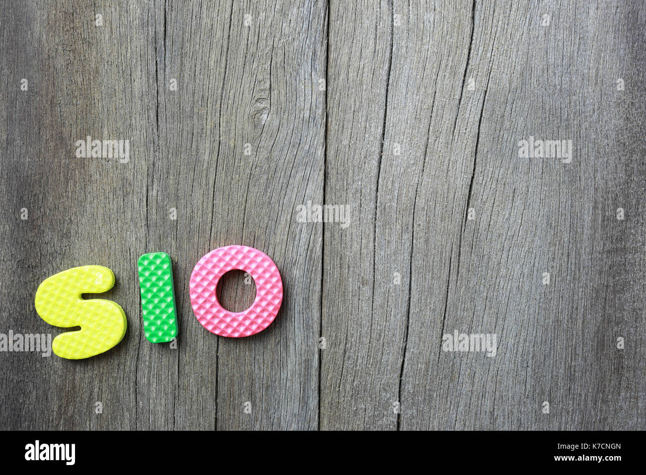L'alfabeto di iso giaceva sul vecchio brown il pavimento di legno di sfondo e di avere copia dello spazio per il vostro lavoro di design. Foto Stock