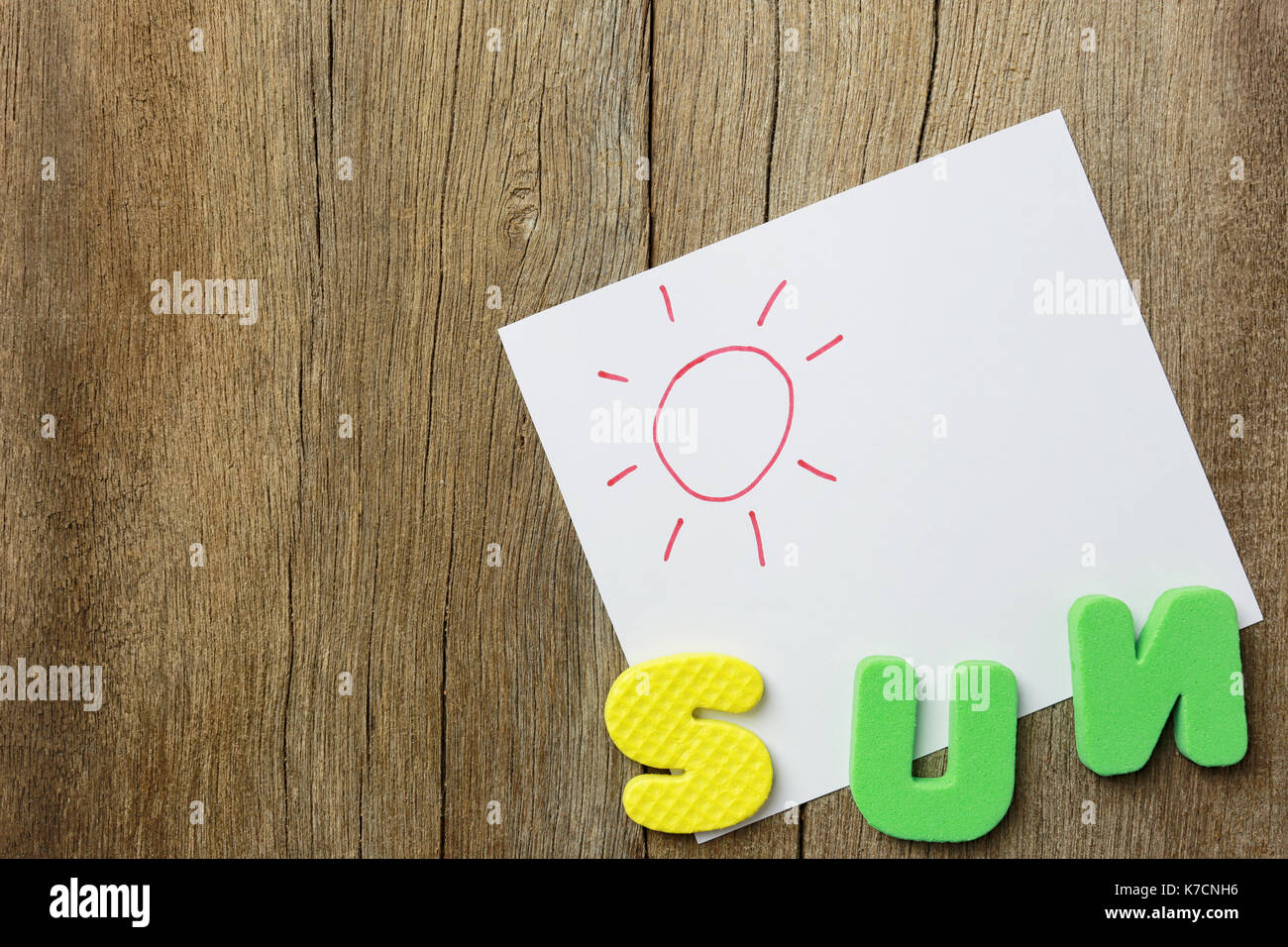 L alfabeto della sun giaceva sul vecchio brown il pavimento di legno di sfondo e di avere copia dello spazio per il vostro lavoro di design. Foto Stock