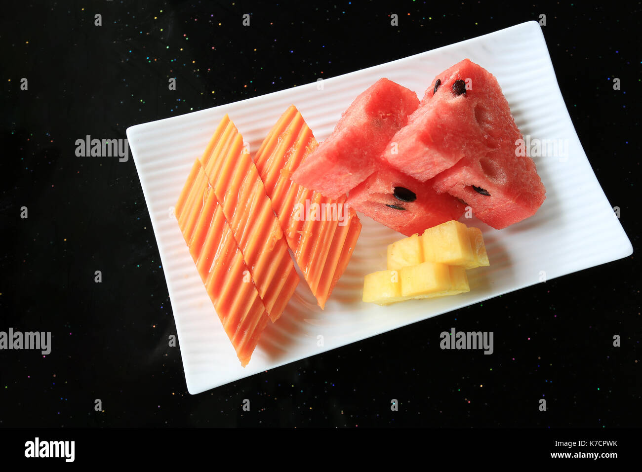 Ananas Papaia ed anguria in piatto bianco su alimenti tabella. Foto Stock