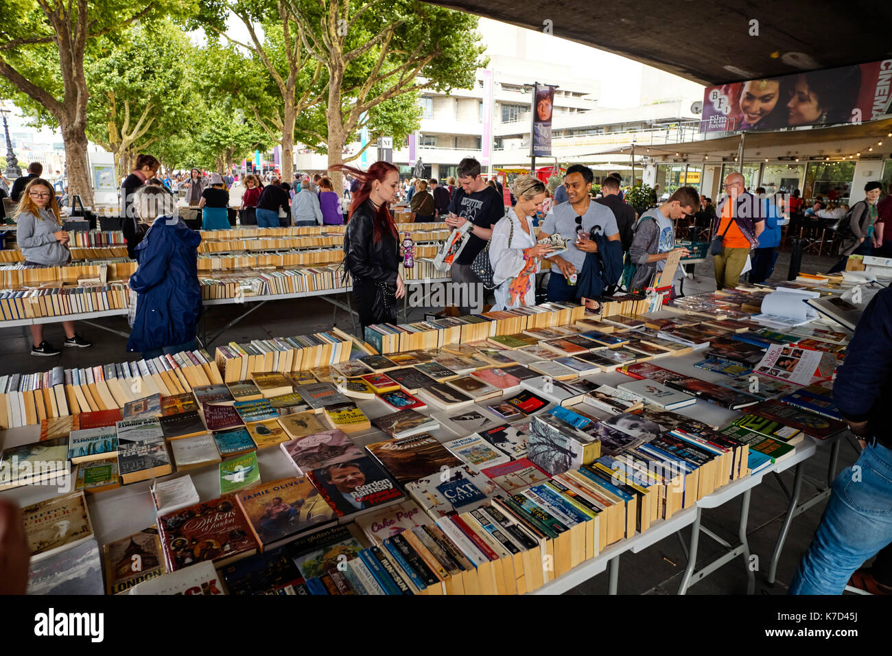 Persone che scelgono i libri presso il Southbank sotto Waterloo Bridge di domenica Foto Stock