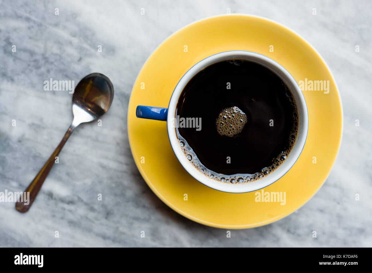 Vista aerea del nero caffè nella tazza e cucchiaio sul tavolo di marmo Foto Stock