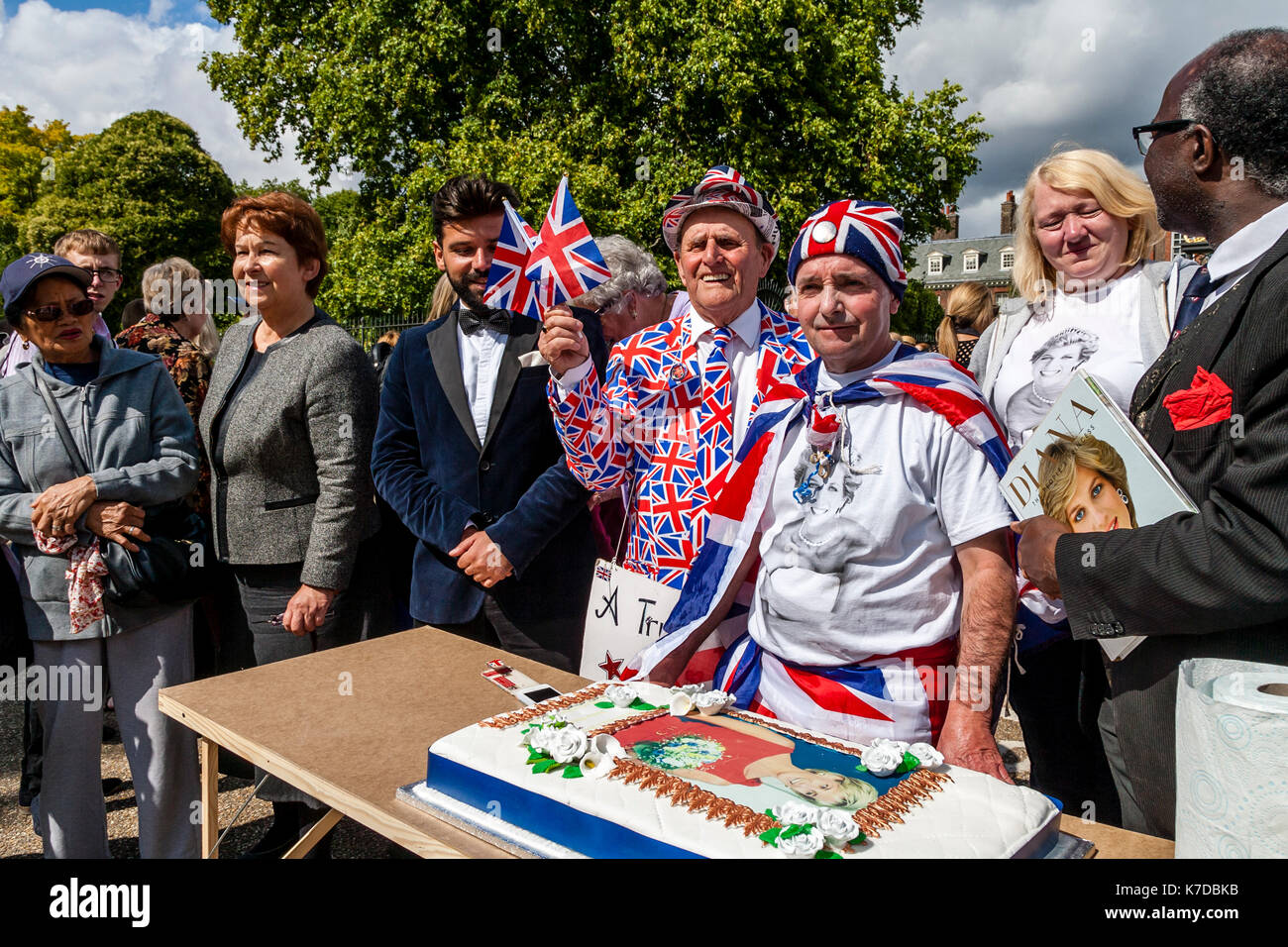 I sostenitori del tardo Princess Diana il taglio di una torta di grandi dimensioni in memoria di lei per il ventesimo anniversario della sua morte, il Palazzo di Kensington, London, Regno Unito Foto Stock