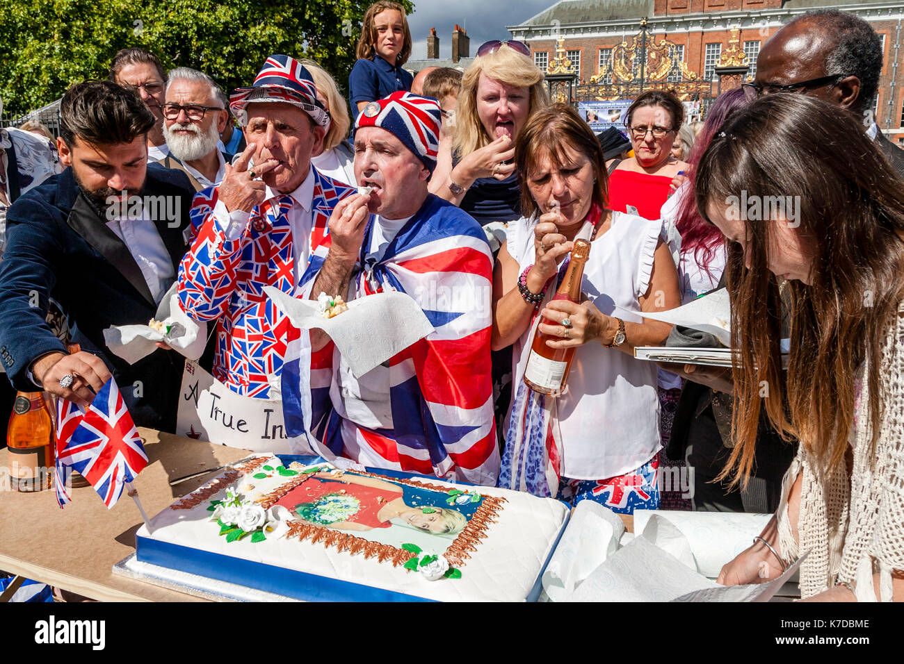 I sostenitori del tardo Princess Diana il taglio di una torta di grandi dimensioni in memoria di lei per il ventesimo anniversario della sua morte, il Palazzo di Kensington, London, Regno Unito Foto Stock