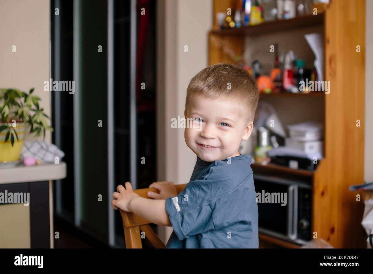 Ritratto di felice ragazzo guardando sopra la spalla a casa Foto Stock