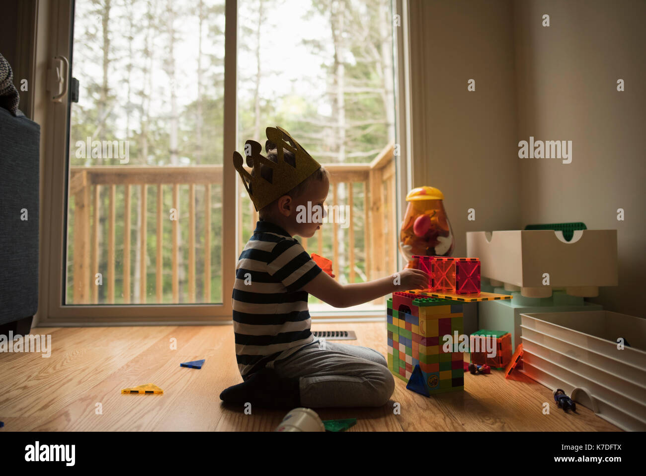 Vista laterale del ragazzo giocando con blocchi giocattolo a casa Foto Stock