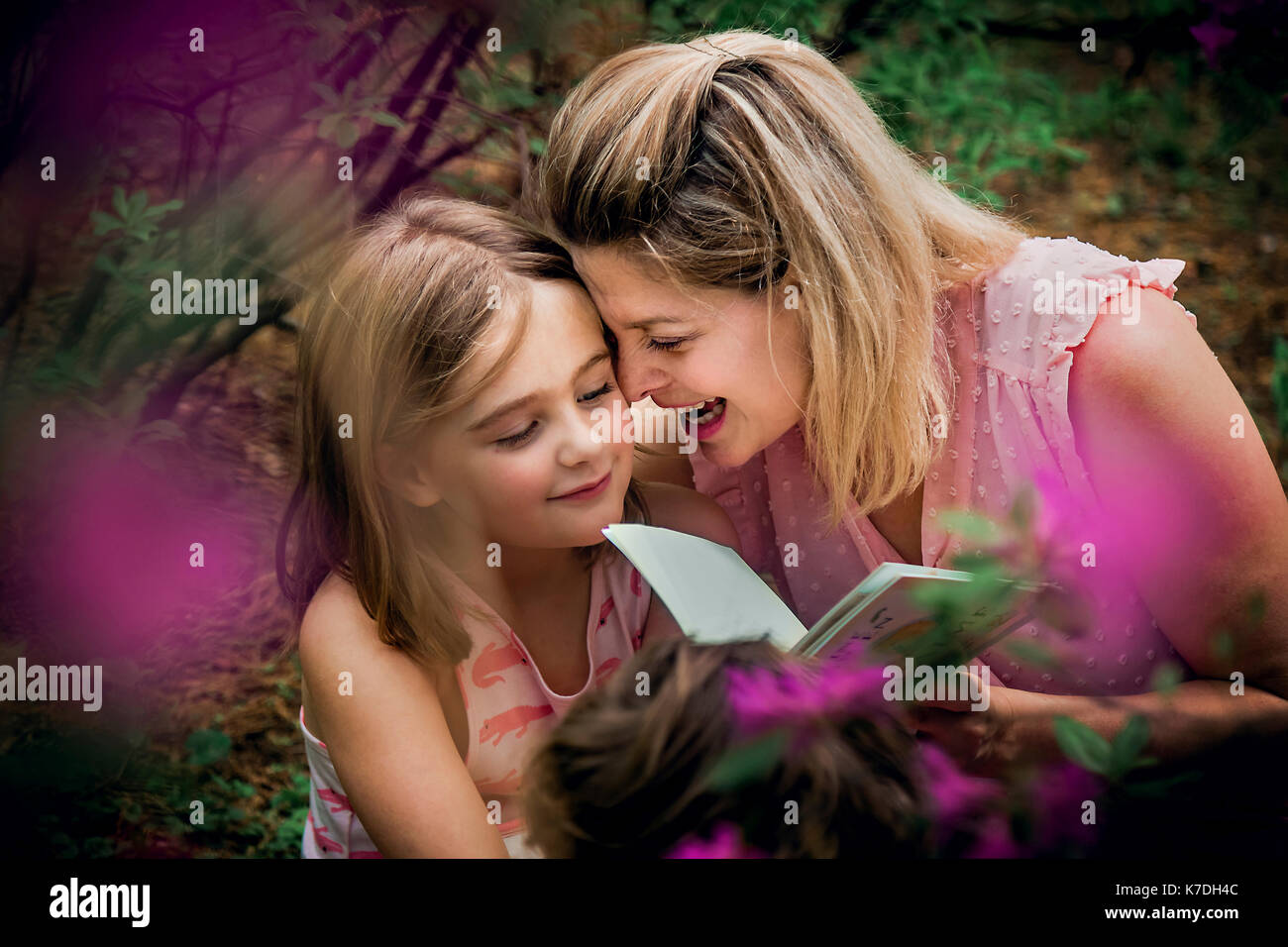 Angolo di alta vista di felice madre e figlia godendo durante la lettura del libro Foto Stock