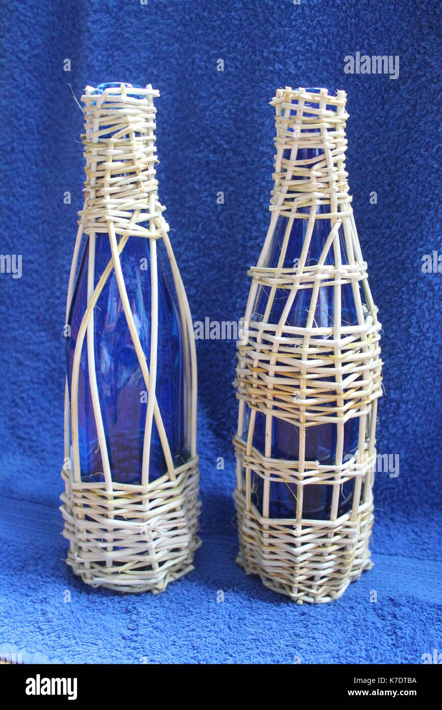 Due vetro fragile bottiglia blu intessute willow per salvare il vino e decorazione Foto Stock
