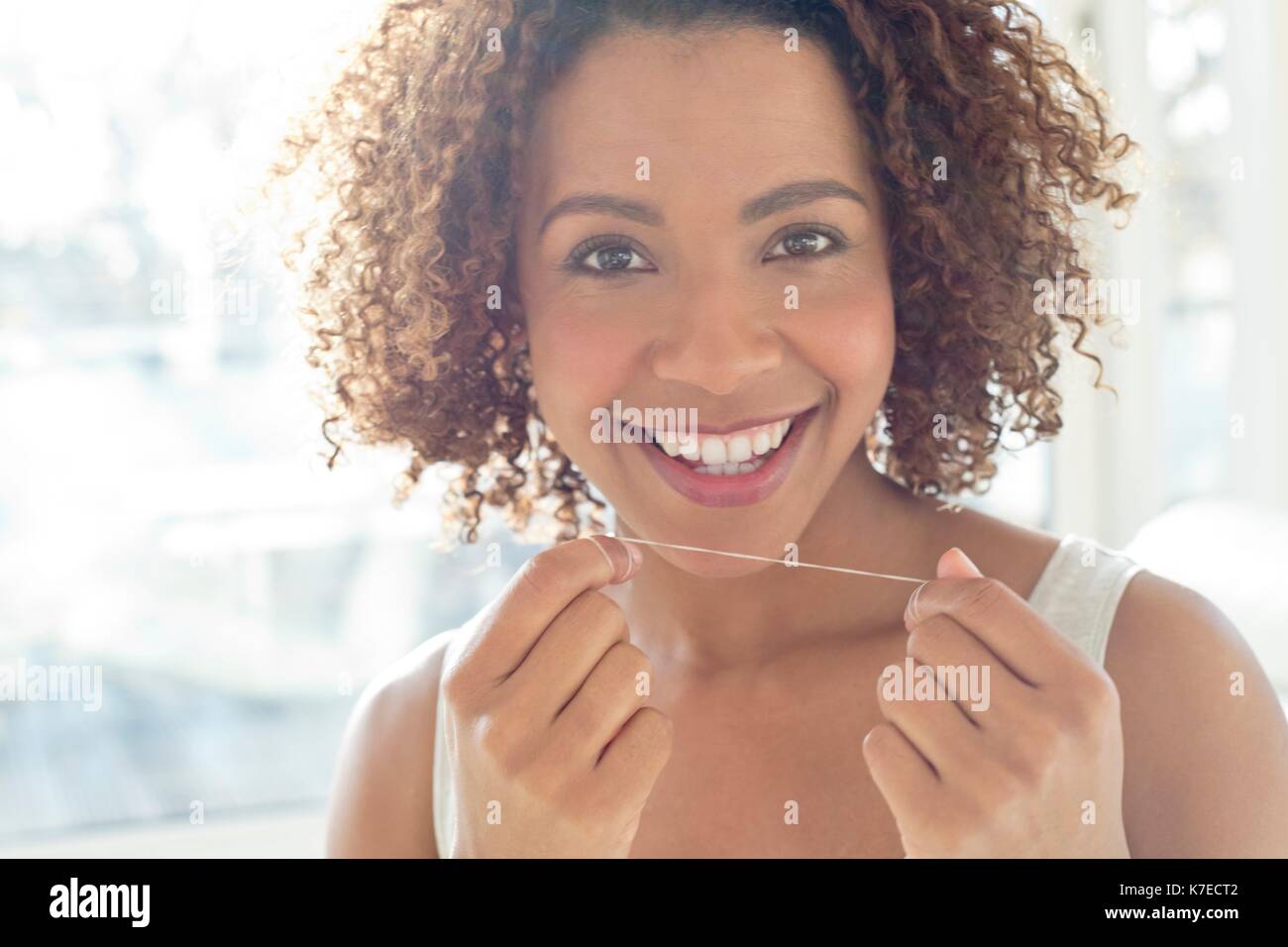 Ritratto di metà donna adulta filo interdentale i denti. Foto Stock
