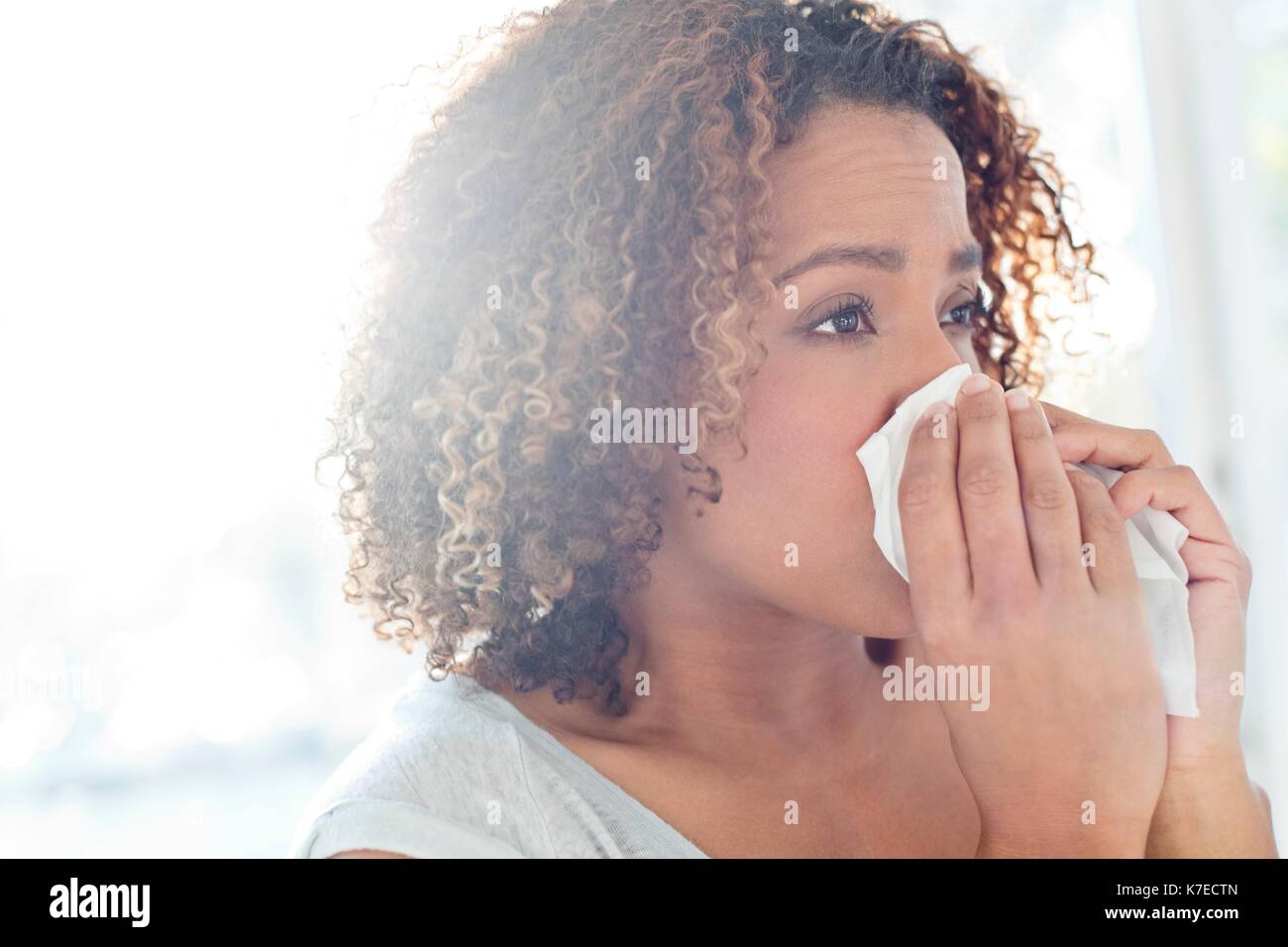 Metà donna adulta soffia il naso sul tessuto. Foto Stock