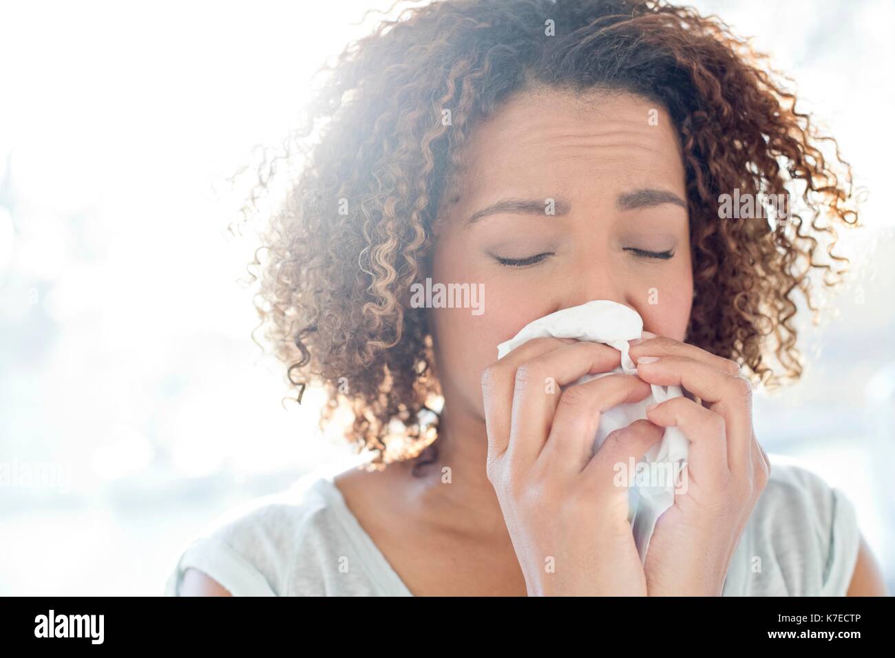 Metà donna adulta soffia il naso sul tessuto. Foto Stock