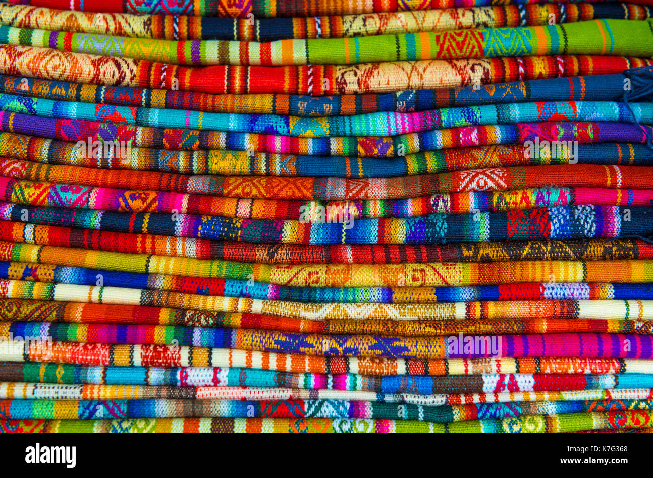 Un mucchio di variopinti tessuti andina fotografato nel locale mercato artigianale di Cusco, Perù. Foto Stock