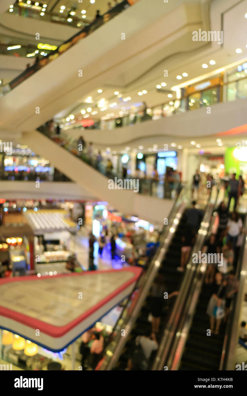 L'immagine verticale di offuscata shopping mall con così tante persone sulle scale mobili Foto Stock