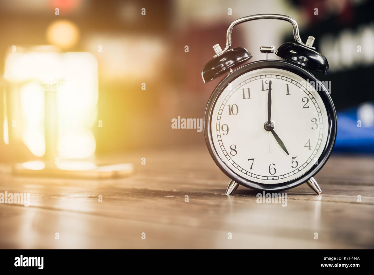 5 ore di tempo di clock retrò su tavola di legno con sun sfondo luminoso Foto Stock