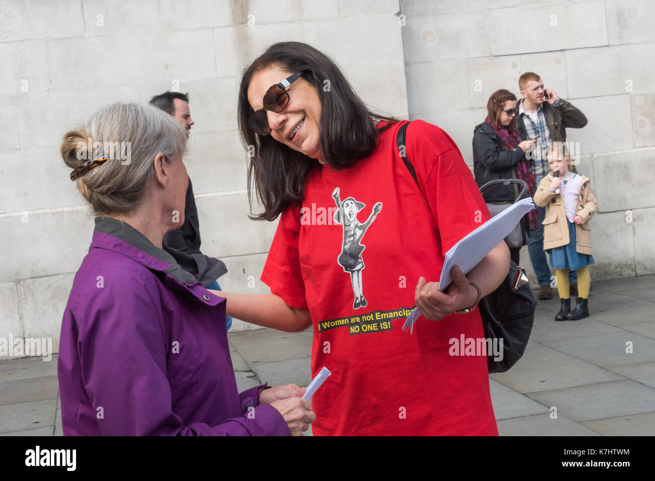 Londra, Regno Unito. Il 16 settembre 2017. Una donna con il messaggio sulla parte anteriore della sua t-shirt "se le donne non sono emancipati NESSUNO!' colloqui a passanti alla protesta dal 8 marzo organizzazione di donne (Iran-Afghanistan) in Trafalgar Square il 29 anniversario della strage dei prigionieri politici in Iraq a seguito di una fatwa dall Ayatollah Khomeini chiamando per la morte di tutti Mojahedins leftists e come "combattenti contro Dio " e " gli apostati dall Islam.' prove recenti confermano le asserzioni che oltre 30.000 prigionieri politici, in gran parte membri del principale partito d opposizione popolare organizzazione Mojahedin Foto Stock