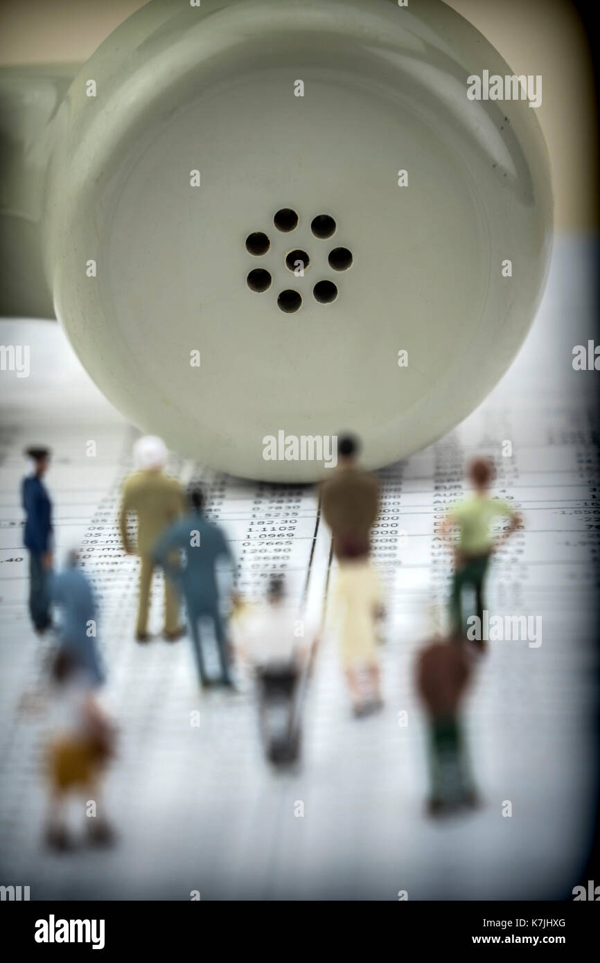 Le figure miniatura contro il ricevitore vecchio telefono isolato su sfondo bianco, immagine concettuale Foto Stock