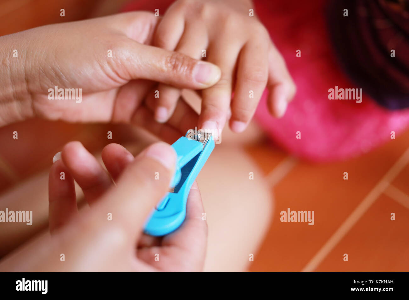 Madre usare Nail clipper a baby per la pulizia del corpo. Foto Stock