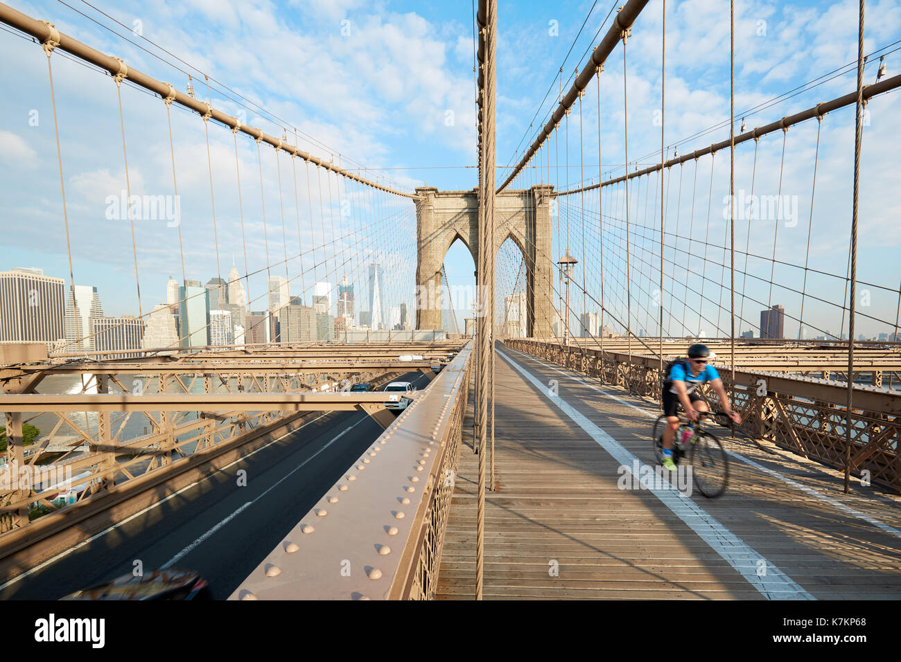 Ponte di Brooklyn in una mattina di sole con uomo ciclismo in New York. Si tratta di un vecchio ponte completata nel 1883. Foto Stock