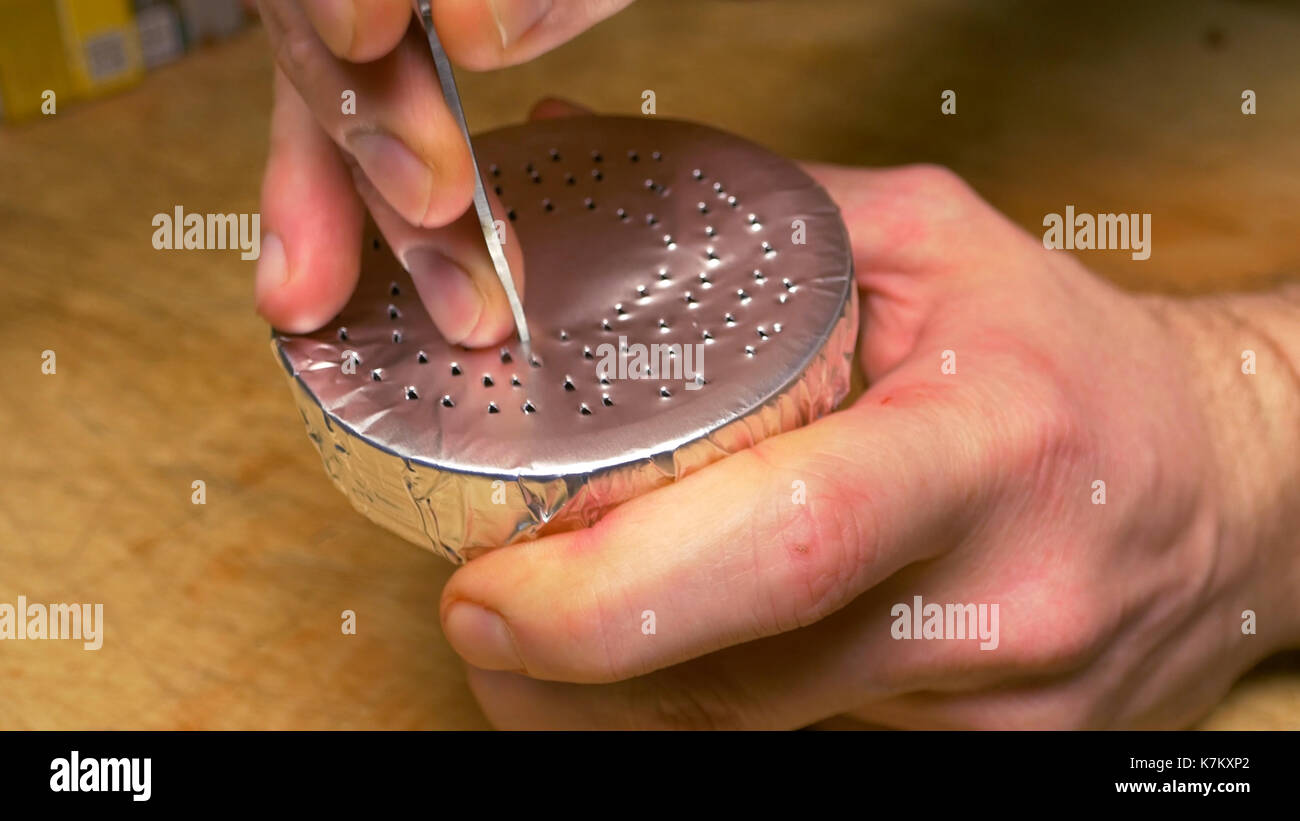 Un uomo si prepara un narghilè con un foglio di alluminio. stiramento della pellicola su shisha bowl. hookah. Preparazione del tabacco. Preparare il shisha, aka nargile o hookah presso un ristorante ponendo i carboni di legna sulla parte superiore Foto Stock