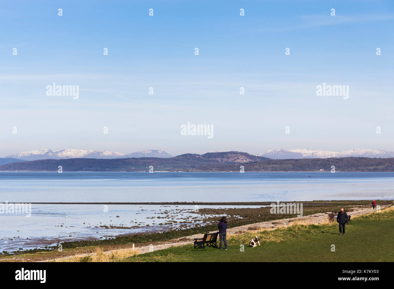 Vista dalla Banca Hest vista attraverso l'angolo nord-est della baia di Morecambe con lo snow-capped fells del Distretto del Lago all'orizzonte. Foto Stock