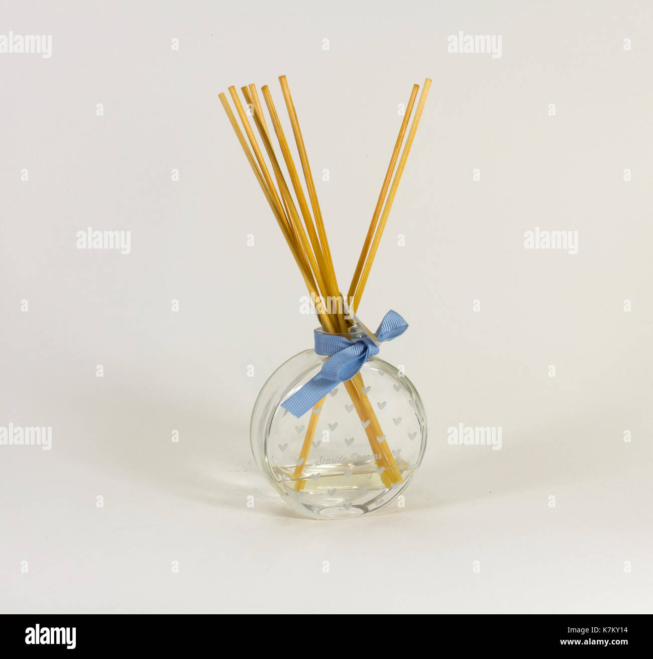 Pettine diffusore di fragranze, pallone di vetro con cuore motif marcature e nastro azzurro intorno al collo. canna bastoni reed gradualmente a diffondere il profumo. Foto Stock