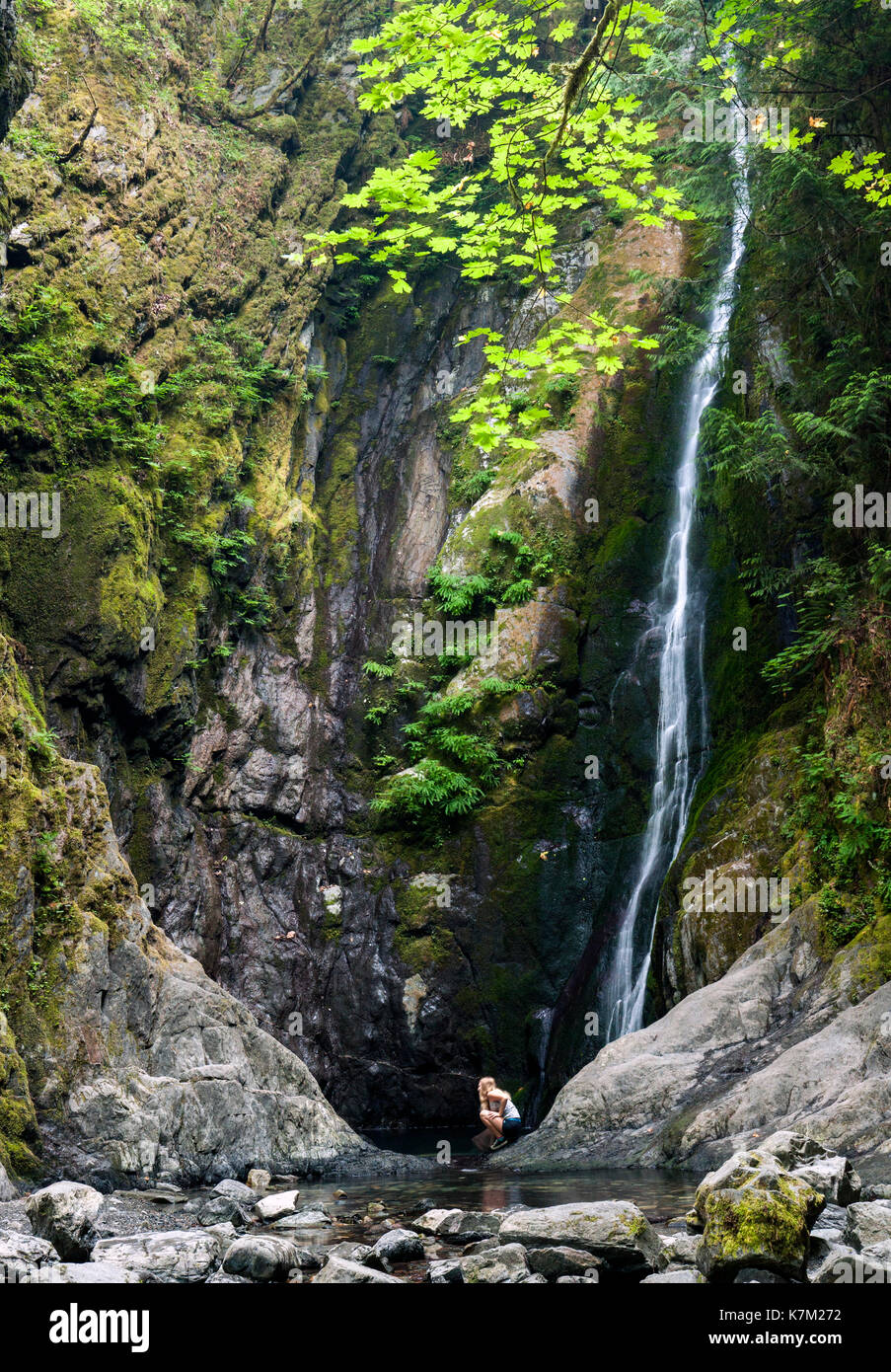 Ragazza giovane alla base delle Cascate del Niagara - goldstream provincial park - victoria, isola di Vancouver, British Columbia, Canada Foto Stock