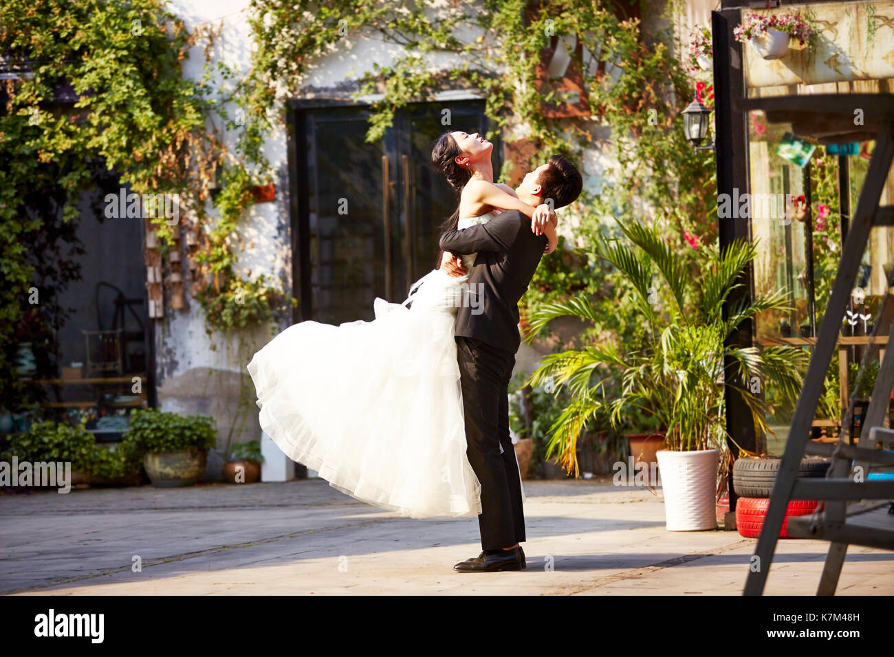 Asian sposi sposa e lo sposo per celebrare il matrimonio al di fuori di un edificio. Foto Stock