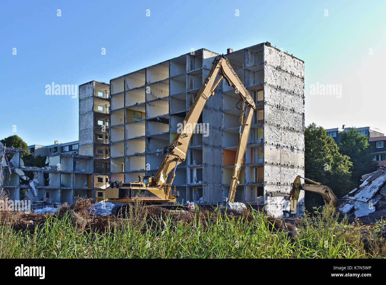 Sito in costruzione con demolito palazzo residenziale per essere demolita da due escavatori Foto Stock
