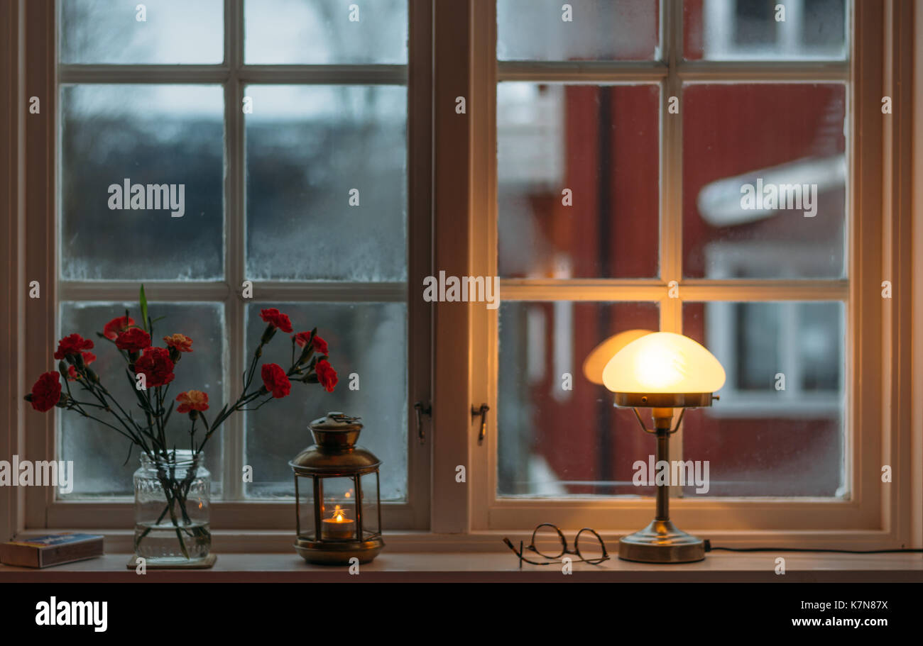 Vista da una finestra accogliente con lampada e fiori Foto Stock
