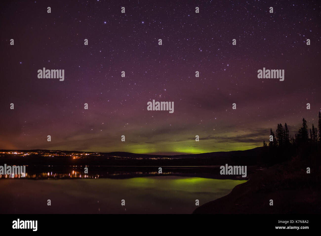 Aurora borealis luci che ballano sul villaggio e sul lago Foto Stock