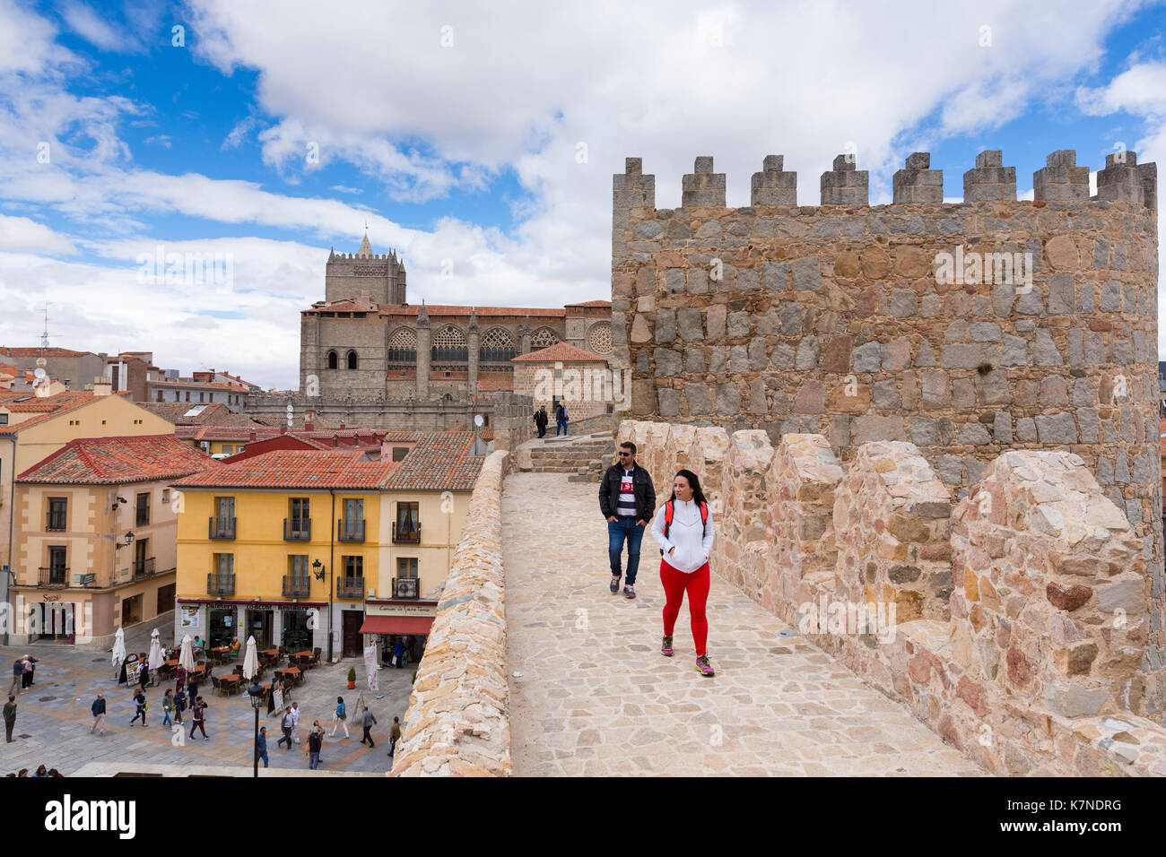 I turisti passeggiano lungo la parte superiore delle mura medievali della città di Avila, Spagna Foto Stock