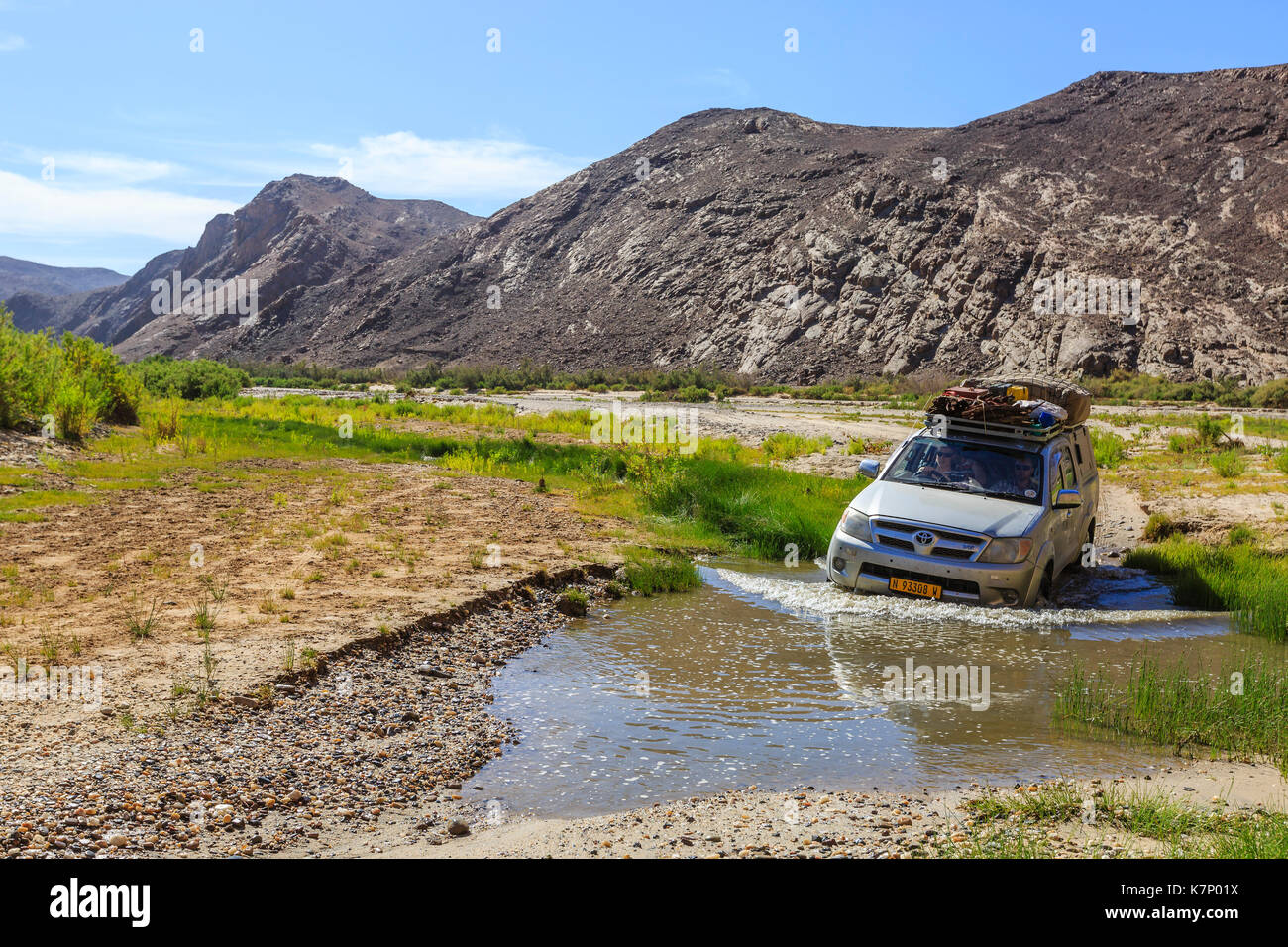 Veicolo fuoristrada attraversa il fiume hoarusib, damaraland, regione di Kunene, Namibia Foto Stock