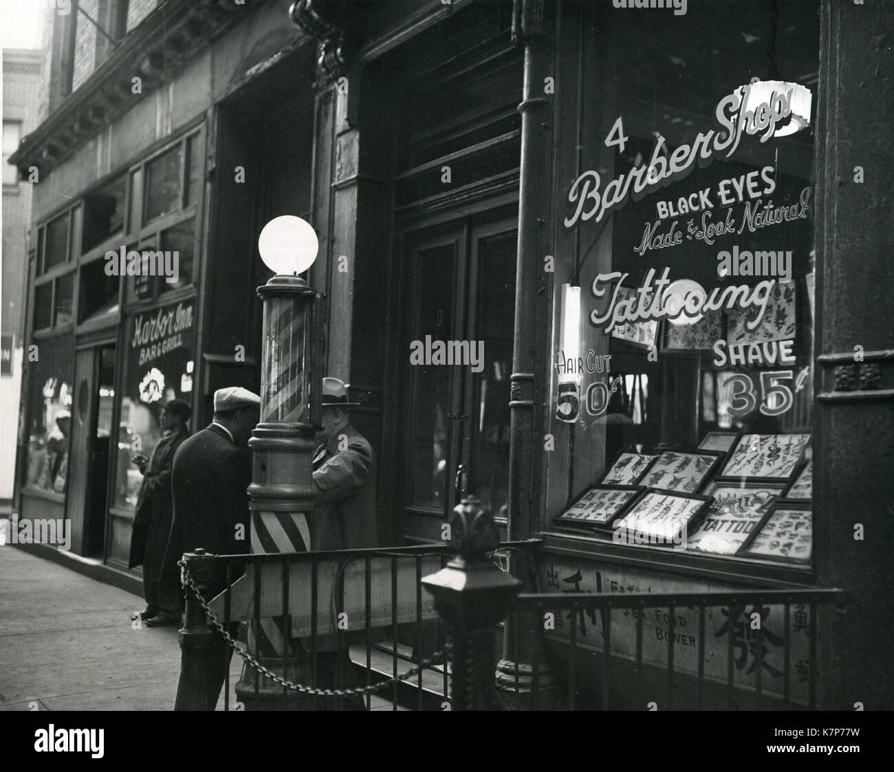 New York, 1952 - un barbiere sulla Bowery, una strada sulla estremità inferiore di Manhattan Island. Questo negozio è specializzato in tatuaggio e 'occhi neri realizzati per un look naturale". Foto Stock