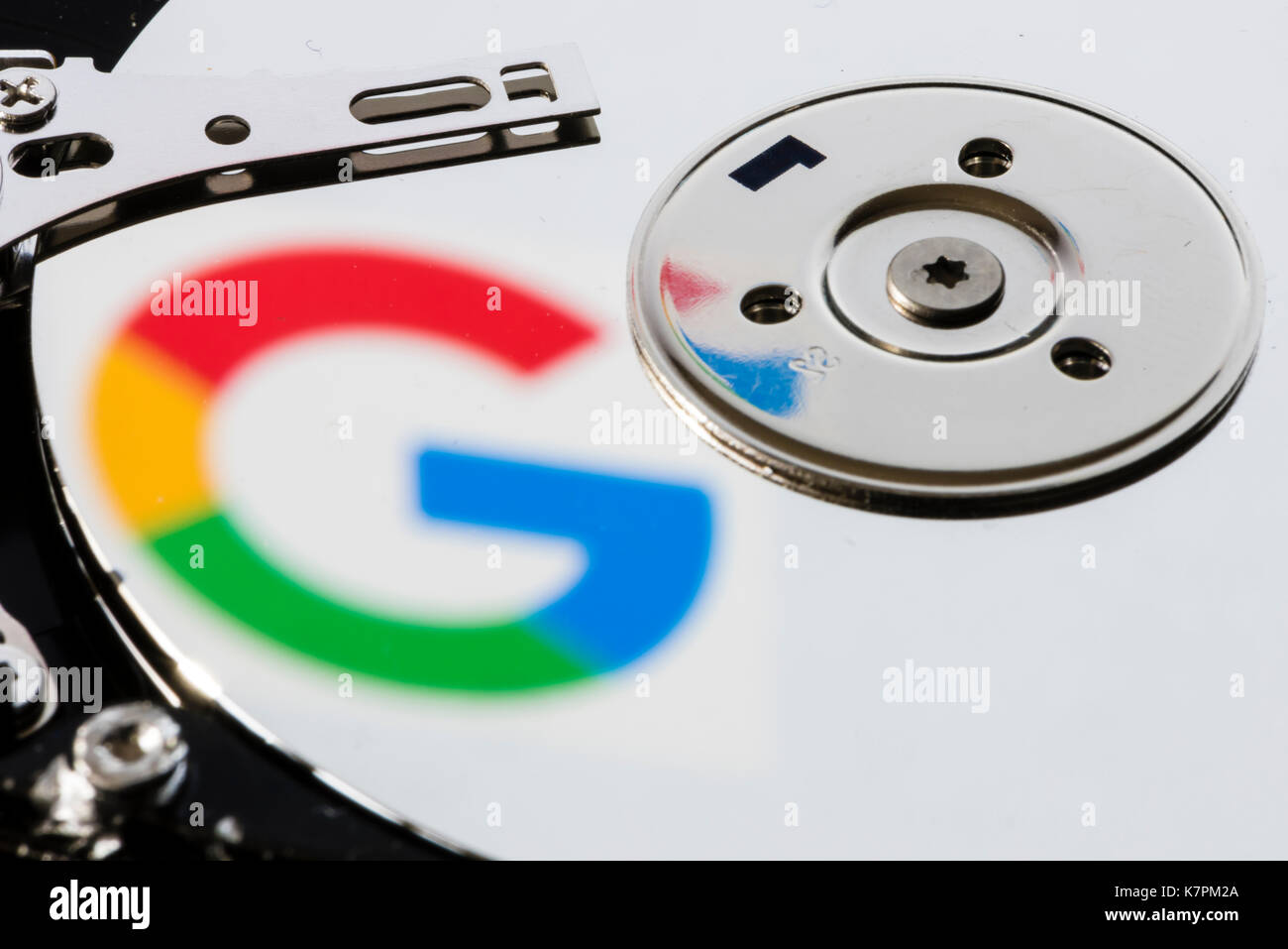 Close-up di un computer aperto unità disco rigido, con la riflessione del logo di Google sul lucido della superficie del disco. Foto Stock