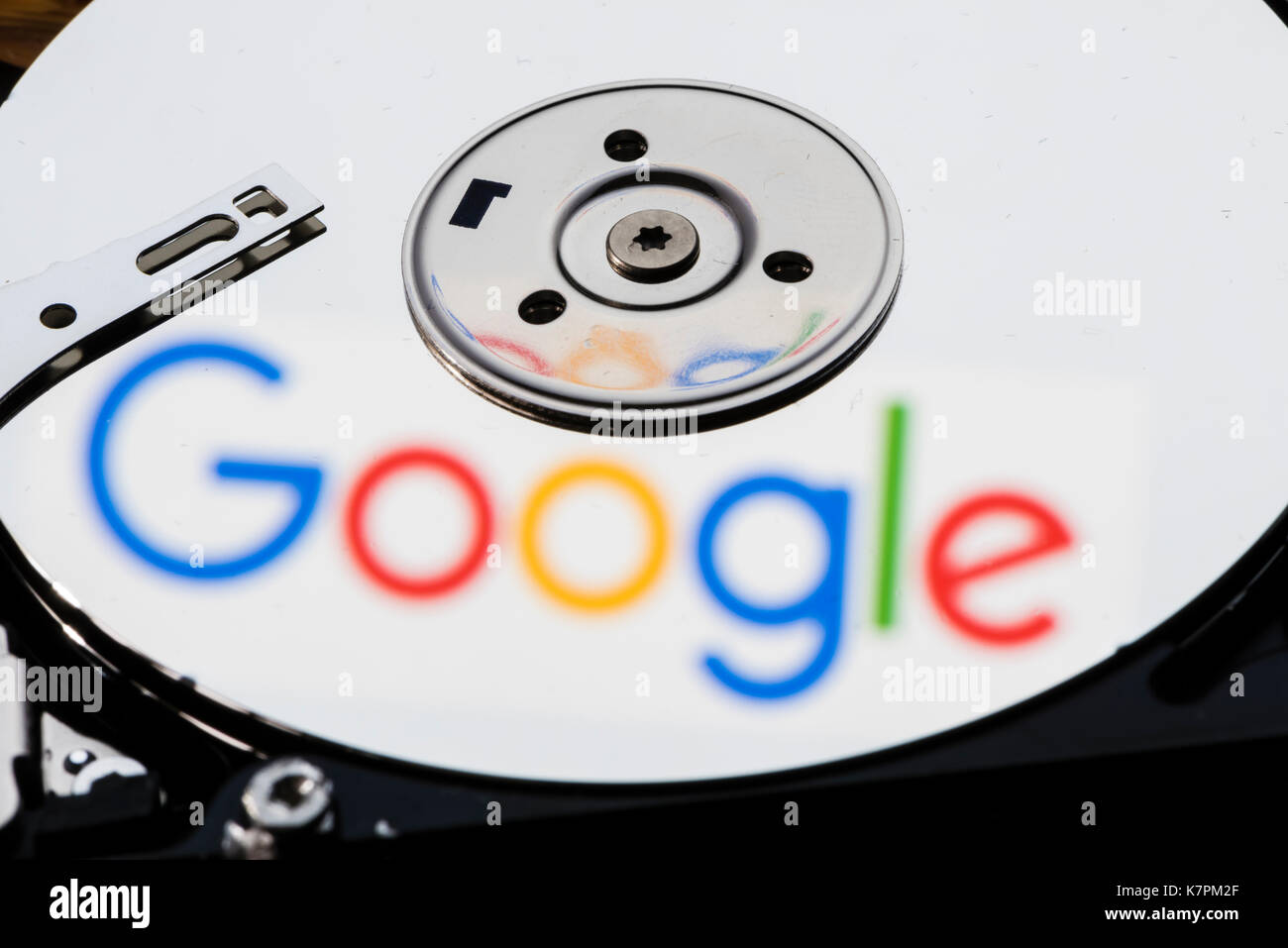 Close-up di un computer aperto unità disco rigido, con la riflessione del logo di Google sul lucido della superficie del disco. Foto Stock