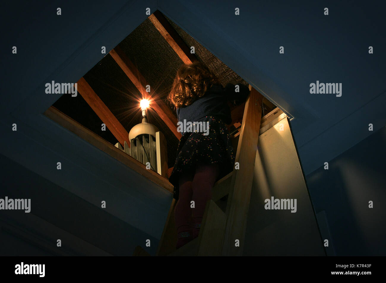 Ragazza salendo una scala in un loft Foto Stock